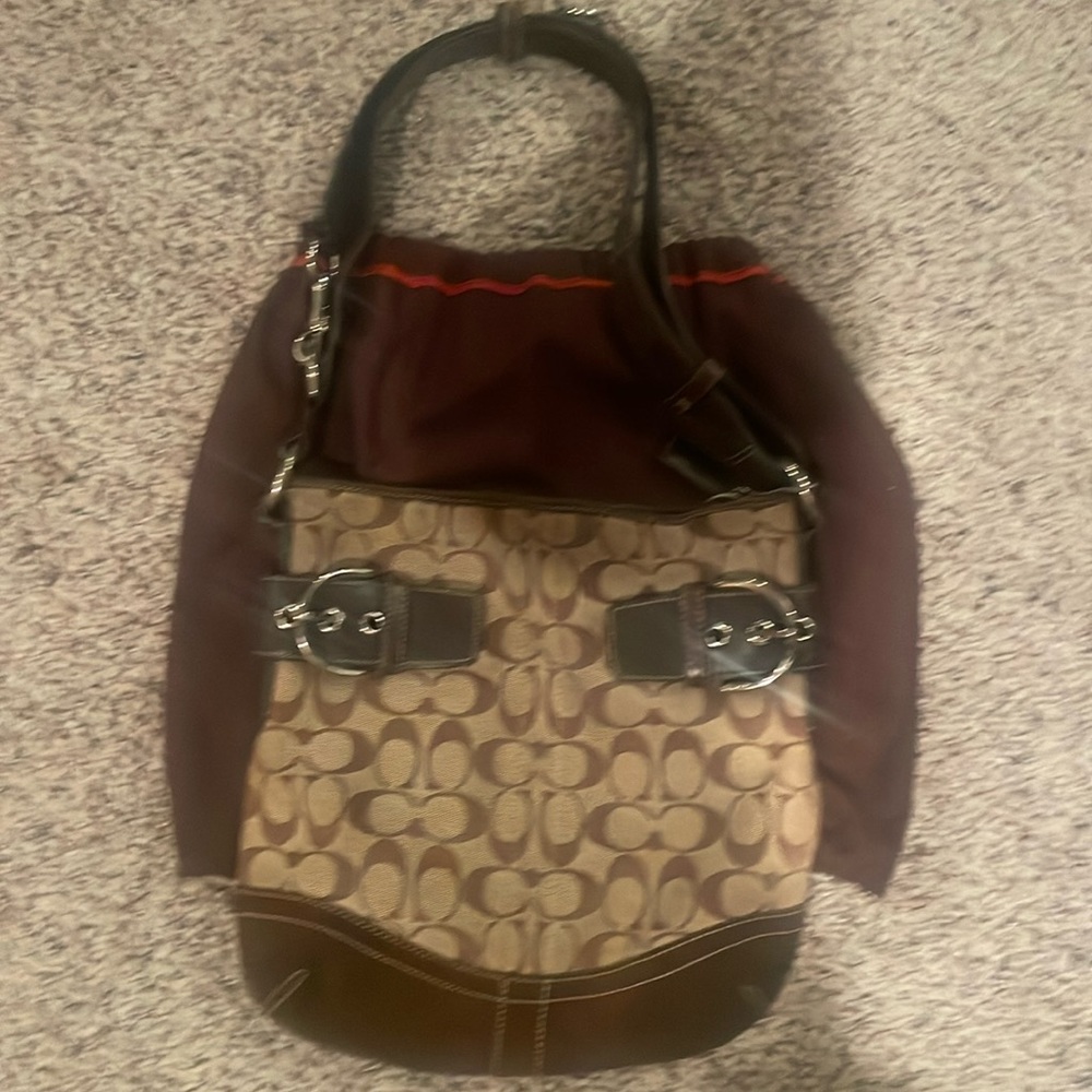 Coach bag with adjustable shoulder strap, includes dust bag.